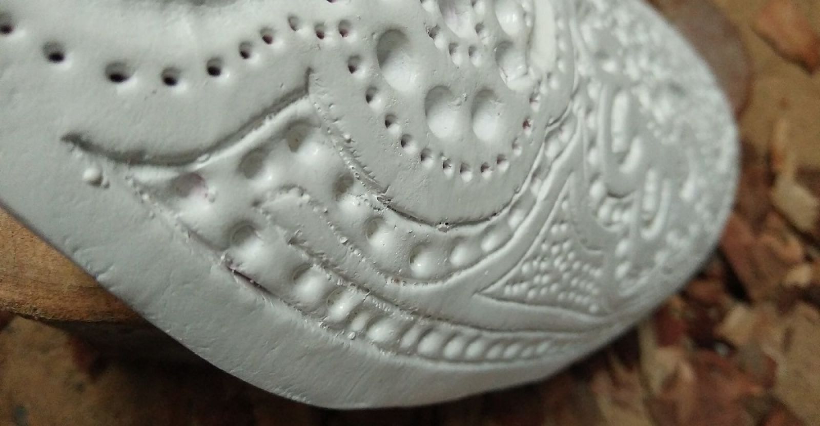 white clay coolamon with carved detail banner image