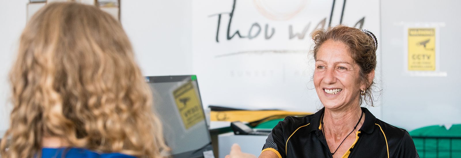 ladies serving someone at a counter banner image