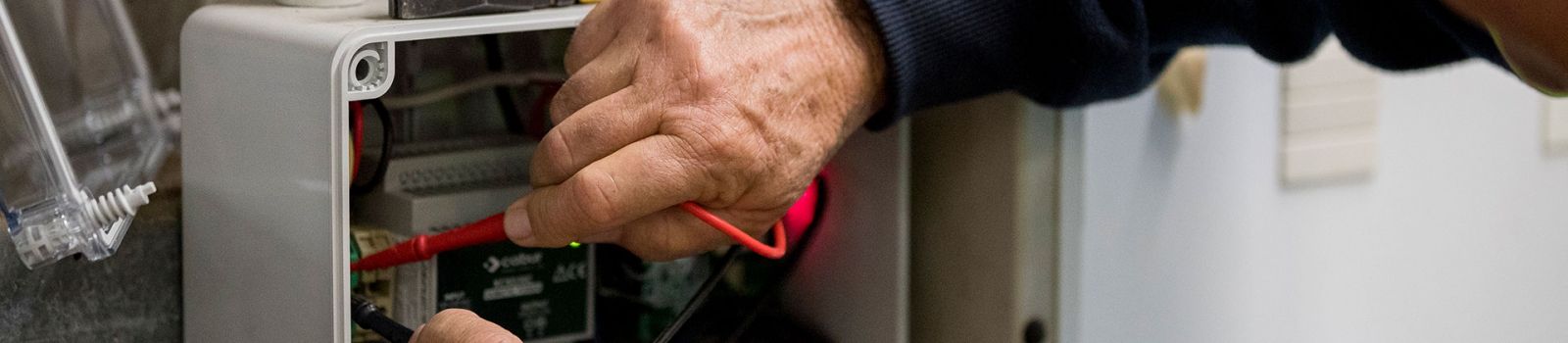 Image of a hand looking into an electrical box  banner image