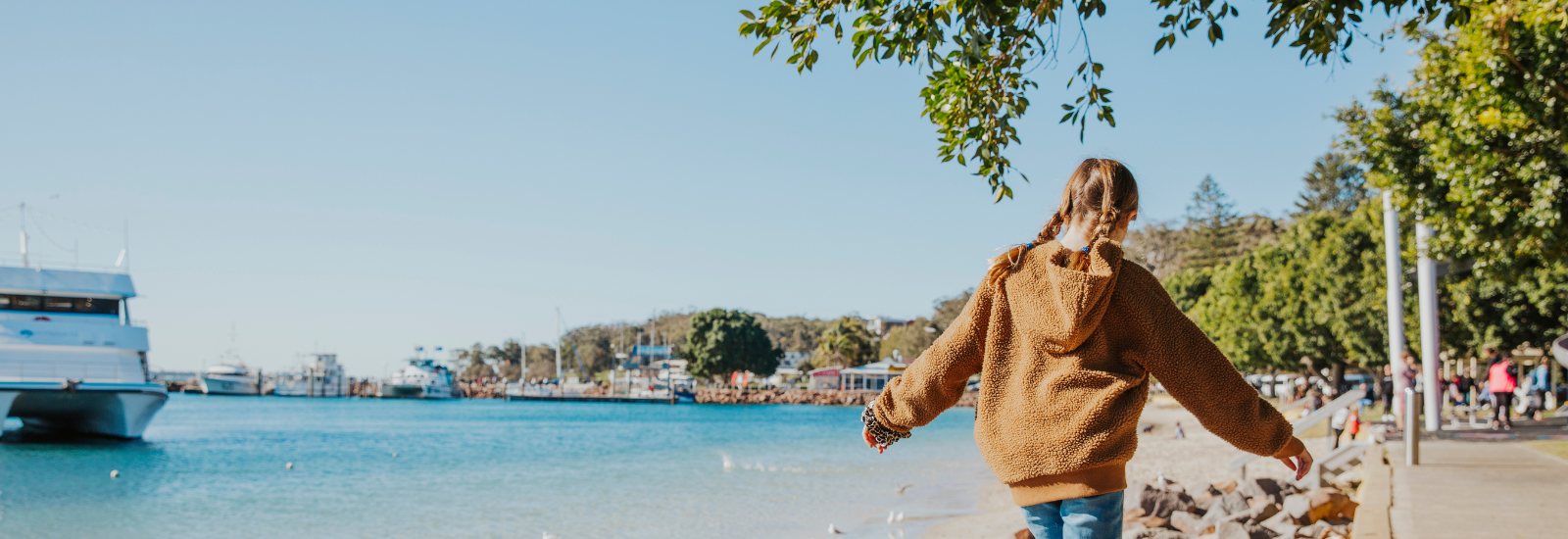 Young girl walking along rocks on Nelson Bay foreshore banner image