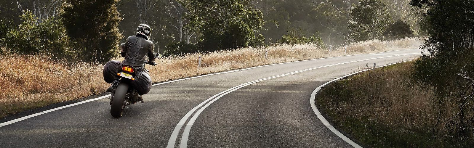 Person on motorbike on the road banner image