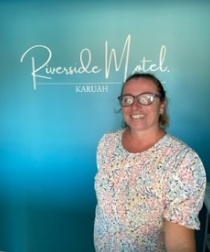 Lisa Floyd standing in front of a Riverside Motel sign