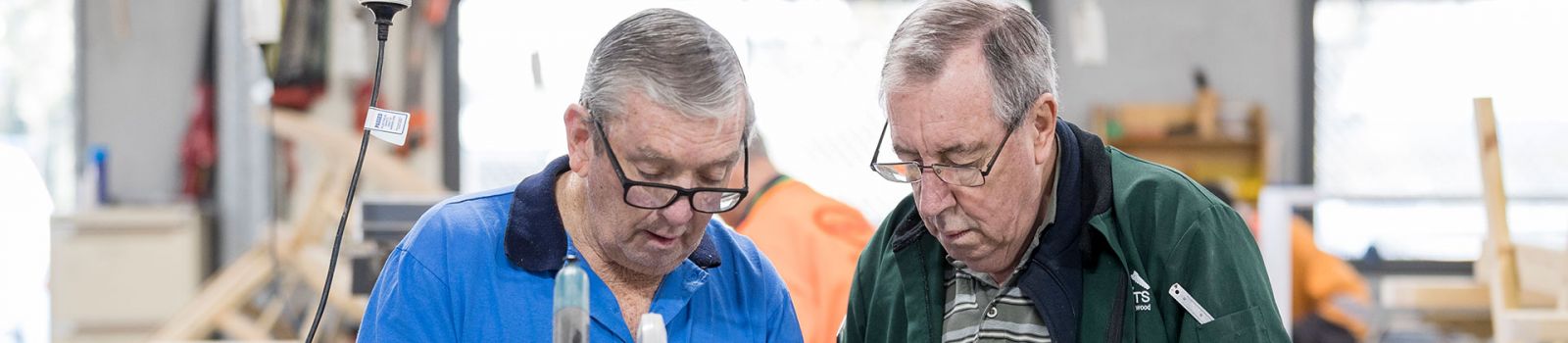 Image of two men looking down at something banner image