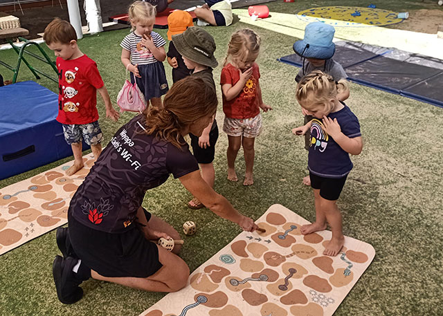 Sarah with children teaching them a game