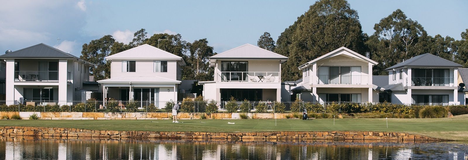 five houses on the edge of a golf course banner image