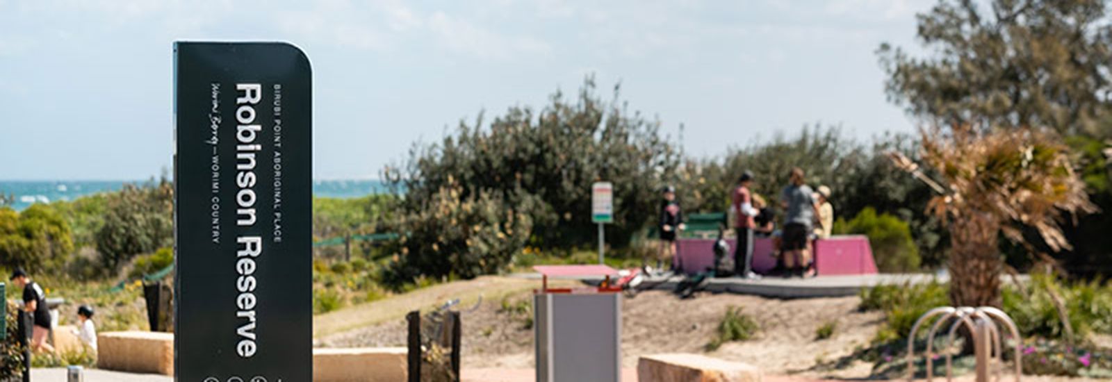 Robertson reserve sign with birubi beach in the background banner image