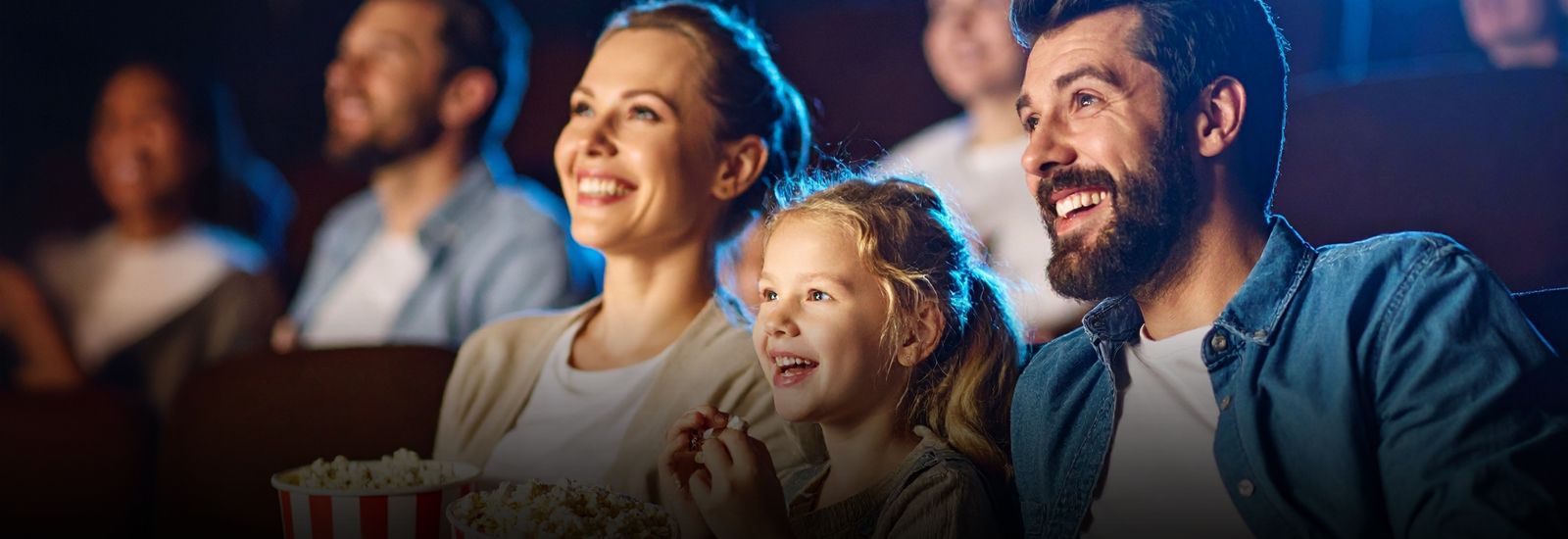 a family sitting at a movie theatre banner image