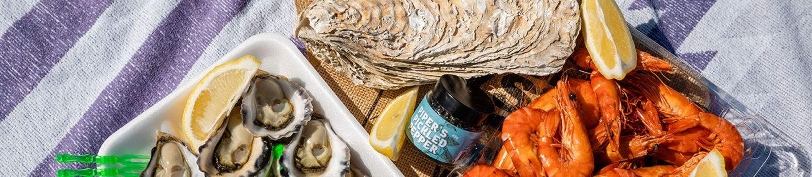 Photo of oysters and prawns on a plate laid out at a restaurant banner image