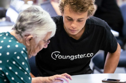 Senior using an ipad with young person helping her