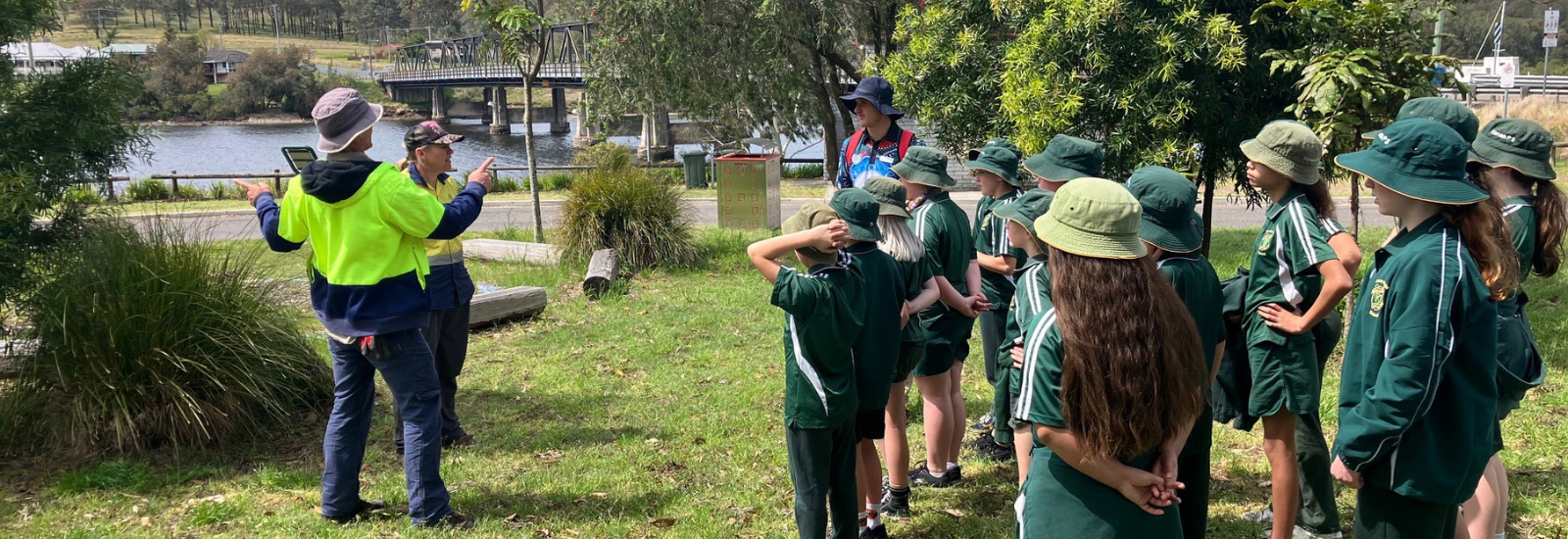 Environmental volunteers talking to a school group banner image