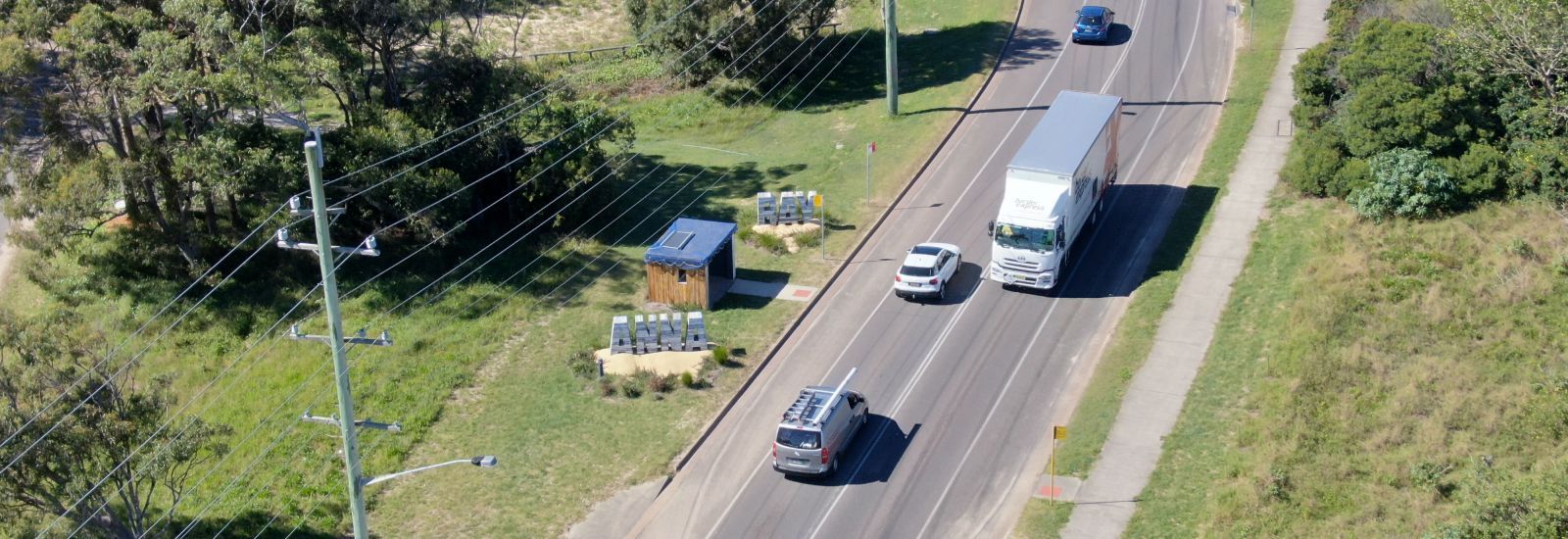 Aerial view of road with a truck and cars on it banner image