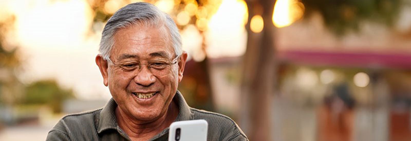 Man holding a phone, smiling banner image