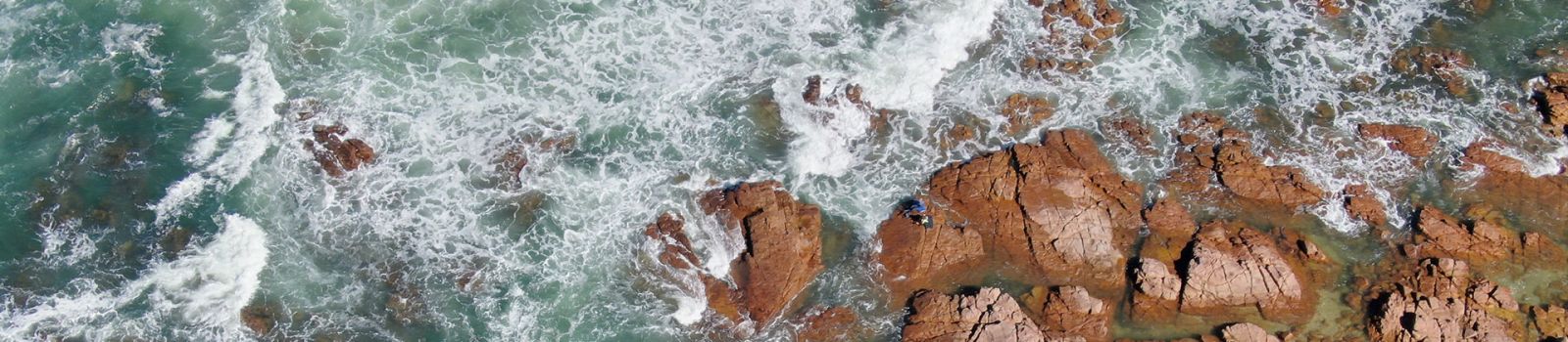 Image of waves crashing against the rocks  banner image