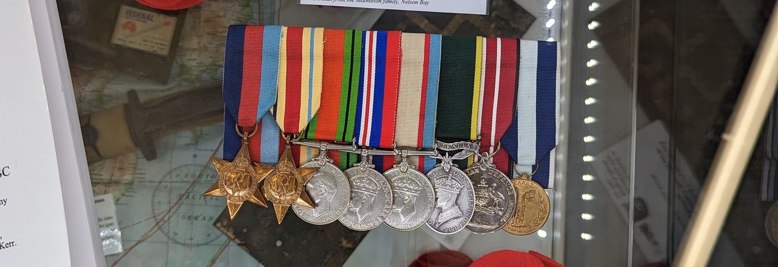 ANZAC medals sitting on a map banner image